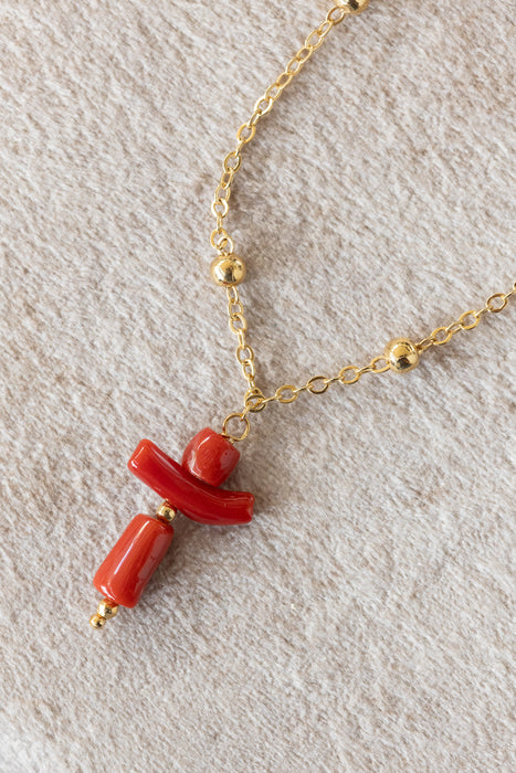 Chaîne boule de 42 cm plaquée or avec pendentif croix bonhomme en corail de 25 mm.
