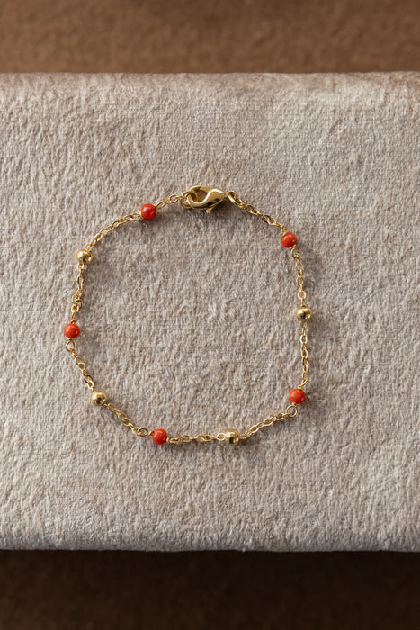 Bracelet de 20 cm plaqué or 24 carats avec boules de diamètre 3 mm plaquées or et perles de corail de diamètre 3 mm.